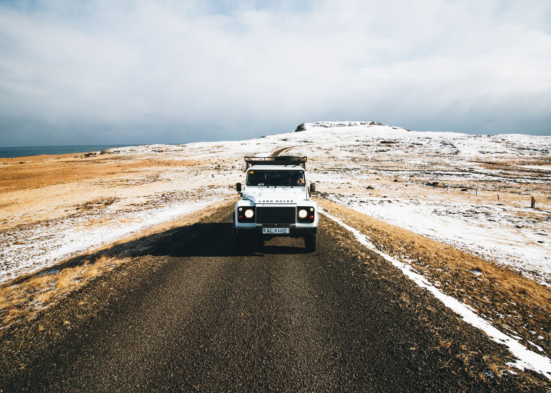 Véhicule Land Rover blanc sur une route en pleine nature